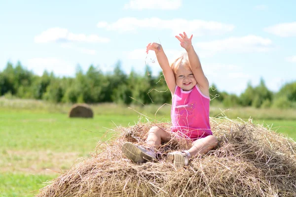 Baby Girl śmiech na letnim stogu siana — Zdjęcie stockowe