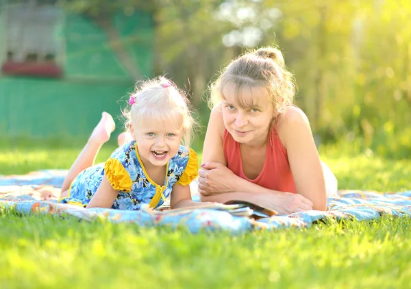 Mother and daughter have rest on nature — Stock Photo, Image