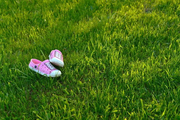 Sandalias coloridas de los niños en el parque infantil césped artificial —  Fotos de Stock