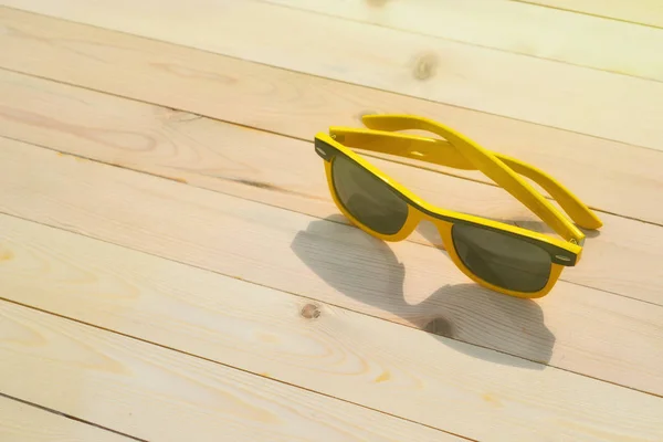 Gafas de sol sobre la mesa con cielo reflectante — Foto de Stock