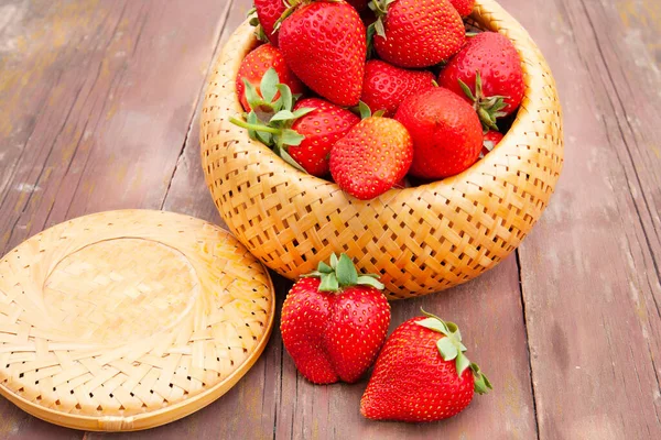 Erdbeeren Einer Weidenkiste Großaufnahme Auf Einem Alten Holztisch lizenzfreie Stockbilder