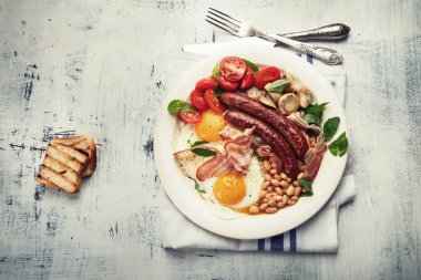 Sahanda yumurta, sosis, fasulye, mantar ve pastırma tam geleneksel İngiliz kahvaltısı