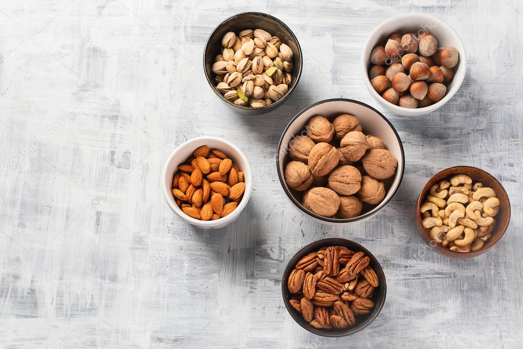 Different kinds of nuts in bowls on table. Healthy food.