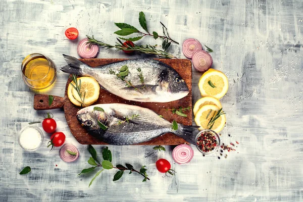 Çiğ dorado balık ahşap kesme tahtası üzerinde baharatlar ile. Üstten görünüm 