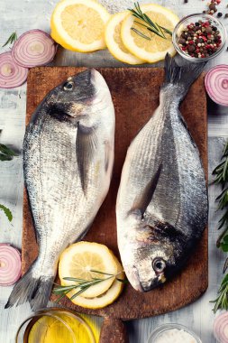 Çiğ dorado balık ahşap kesme tahtası üzerinde baharatlar ile. Üstten görünüm 