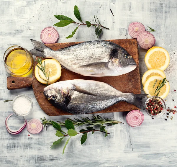 Çiğ dorado balık ahşap kesme tahtası üzerinde baharatlar ile. Üstten görünüm 