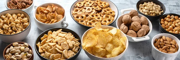 stock image Different kids of snacks, chips, nuts and popcorn