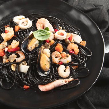 Siyah deniz mahsulleri spagetti. Siyah gıda natürmort 
