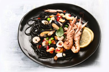Bilinenlerin ve limon siyah deniz mahsulleri spagetti. Siyah gıda natürmort 