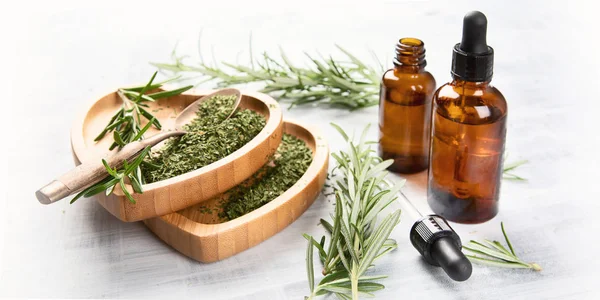 Natural rosemary essential oil with fresh rosemary twigs