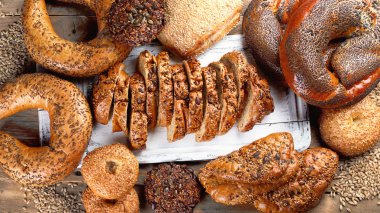 Üstten görünüm taze kepekli ekmek rustik ahşap masa üzerinde karışık.