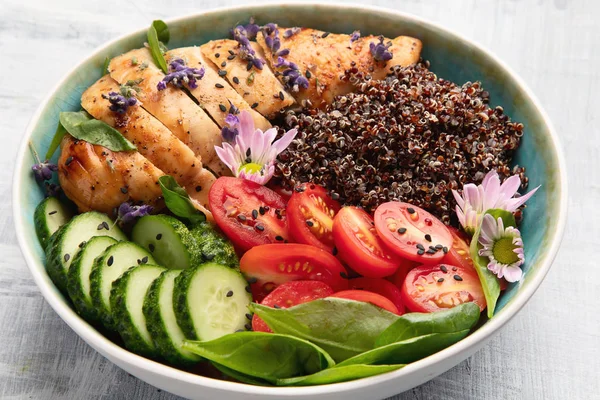 Healthy bowl with roasted chicken and quinoa. Balanced lunch bowl.