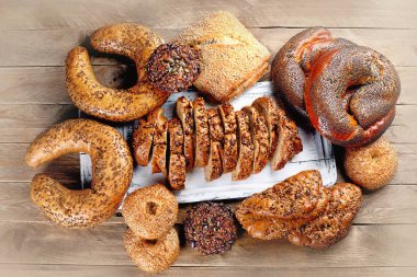 Üstten görünüm taze kepekli ekmek rustik ahşap masa üzerinde karışık.