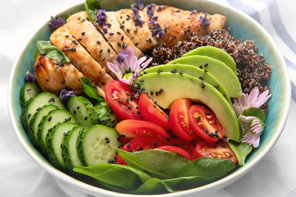Healthy bowl with roasted chicken and quinoa. Balanced lunch bowl.