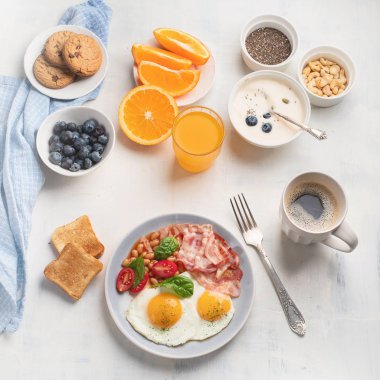Kızarmış yumurta, pastırma, portakal suyu, yoğurt ve tost kahvaltı. Düz yatıyordu