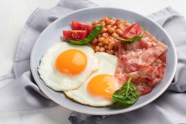 Tabak kızarmış yumurta, pastırma, fasulye, portakal suyu ve tost ile kahvaltı. Kopya alanı ile üstten görünüm