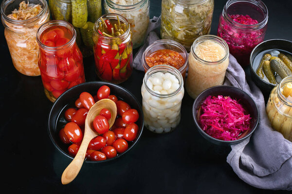 Ферментированная консерва. Маринованные огурцы овощи в стеклянных банках
.