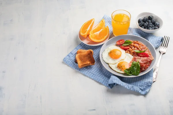 Frühstücksteller Mit Spiegeleiern Speck Bohnen Orangensaft Und Toast Mit Kopierraum — Stockfoto