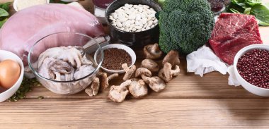 demir yönünden zengin besinler karaciğer, et, yumurta, mercimek, fasulye, brokoli, mantar, guinoa ve deniz ürünleri ahşap masa üzerinde olarak. Sağlıklı beslenme kavramı