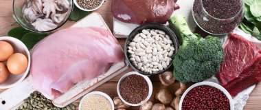 demir yönünden zengin besinler karaciğer, et, yumurta, mercimek, fasulye, brokoli, mantar, guinoa ve deniz ürünleri ahşap masa üzerinde olarak. Sağlıklı beslenme kavramı