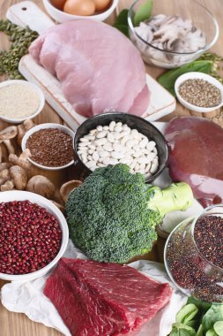 demir yönünden zengin besinler karaciğer, et, yumurta, mercimek, fasulye, brokoli, mantar, guinoa ve deniz ürünleri ahşap masa üzerinde olarak. Sağlıklı beslenme kavramı