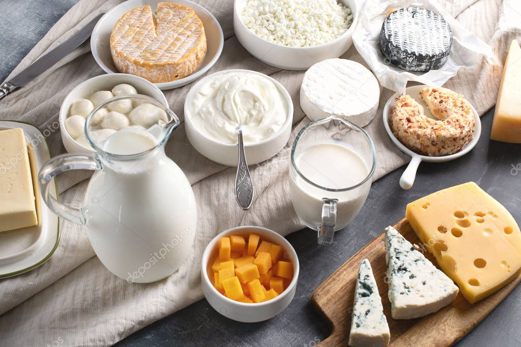 Dairy products.  Milk, cheese, sour cream, cottage, yogurt and butter on dark background
