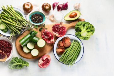 Masa üstü, sağlıklı gıda kavramı üzerinde mevsimlik vegan sebze ve nar yükseltilmiş görünümü