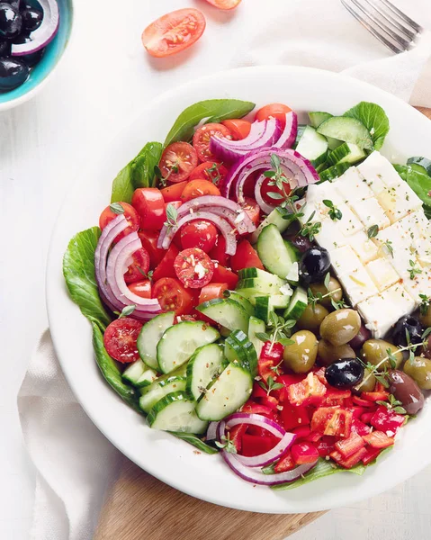 在盘子里放着费塔 橄榄和西红柿的美味希腊沙拉的顶视图 — 图库照片