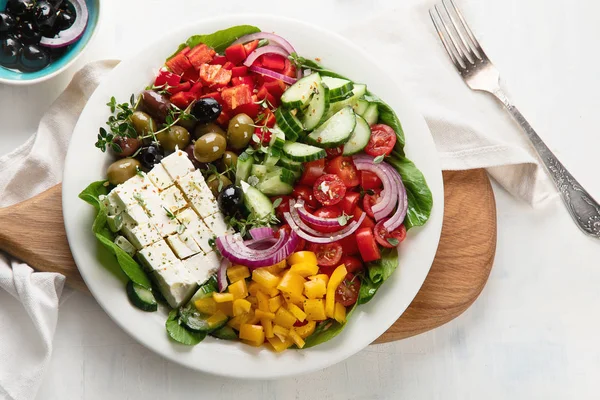 美味的希腊沙拉的顶部视图与费塔 橄榄和西红柿在盘子里 — 图库照片