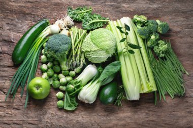 Ahşap masa, üstten görünüm taze yeşil sebze.