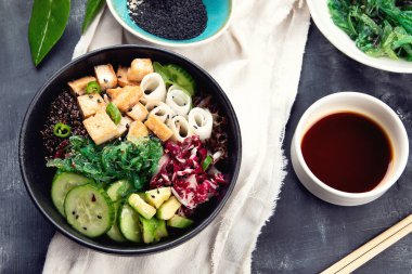 Quinoa, sebze ve tofu koyu arka plan üzerinde bir vegan kase