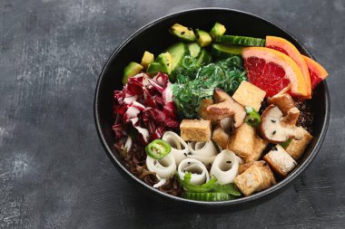 Quinoa, sebze ve tofu koyu arka plan üzerinde bir vegan kase