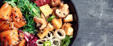 Somon, quinoa, sebze, meyve ve tofu kopya alanı ile koyu arka plan üzerinde kase poke