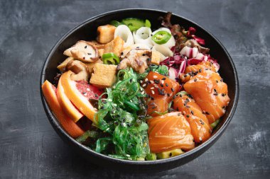 Somon, quinoa, sebze, meyve ve tofu koyu arka plan üzerinde kase poke