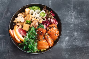 Somon, quinoa, sebze, meyve ve tofu kopya alanı ile koyu arka plan üzerinde kase poke