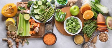 Taze sağlıklı vegan ve vejetaryen yemek gri arka plan üzerinde. Diyet, detoks, temiz kavramı yeme. Üstten görünüm. Panorama, afiş