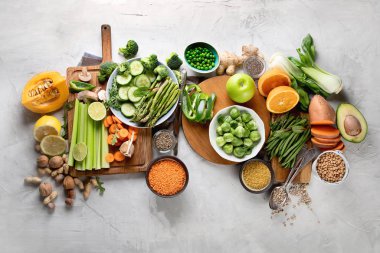 Taze sağlıklı vegan ve vejetaryen yemek gri arka plan üzerinde. Diyet, detoks, temiz kavramı yeme. Kopya alanı ile üstten görünüm