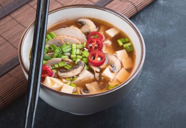 Asya baharatlı çorba tofu ve koyu arka plan üzerinde tavuk ile. 
