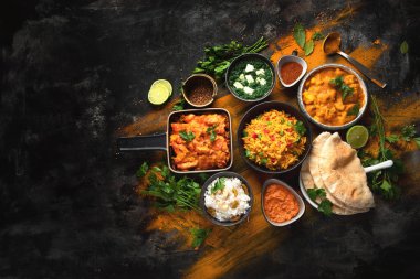 Assorted indian food on black background.. clipart