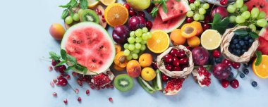 Gri arka planda taze sağlıklı meyveler. Yüksek miktarda antioksidan, karbonhidrat, mineral ve vitamin içeren yiyecekler. Bağışıklık güçlendirici yemek. Kopyalama alanı olan üst görünüm. Panorama, bayrak