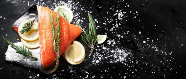 Taze balık. Siyah arka planda çiğ somon balığı. Kopyalama alanı olan üst görünüm. Panorama, bayrak