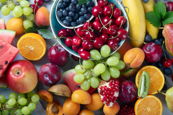 Fresh healthy fruits on grey background. Foods high in antioxidants, carbs,  minerals and  vitamins. Food for immune boosting. Top view 