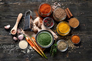 Kırsal ahşap arka planda yemek pişirmek için çeşitli baharatlar. Üst görünüm 