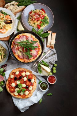 Koyu arkaplanda İtalyan yemekleri makarna, pizza, üst manzara, fotokopi alanı