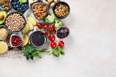 Beyaz ahşap arka planda sağlıklı yiyecek seçimi. Taze meyve, süper yiyecekler, sebzeler. Yüksek miktarda antioksidan, vitamin, mineral ve lif. Kopyalama alanı olan üst görünüm 