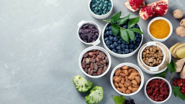 Gri arka planda çeşitli abur cuburlar. Sağlıklı organik yiyecekler. Temiz yemek. Üst görünüm, kopyalama alanı olan düz uzanma.