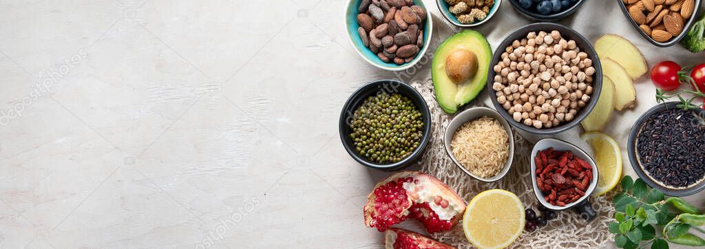 Healthy food selection on white wooden background . Fresh fruits , superfoods an vegatables . High in antioxidants, vitamins, minerals, fiber. Top view, panorama 