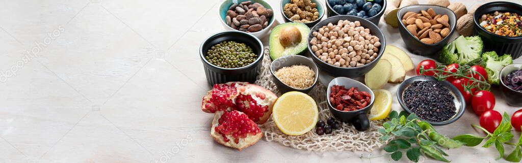 Healthy food selection on white wooden background . Fresh fruits , superfoods an vegatables . High in antioxidants, vitamins, minerals, fiber. Panorama with copy space 