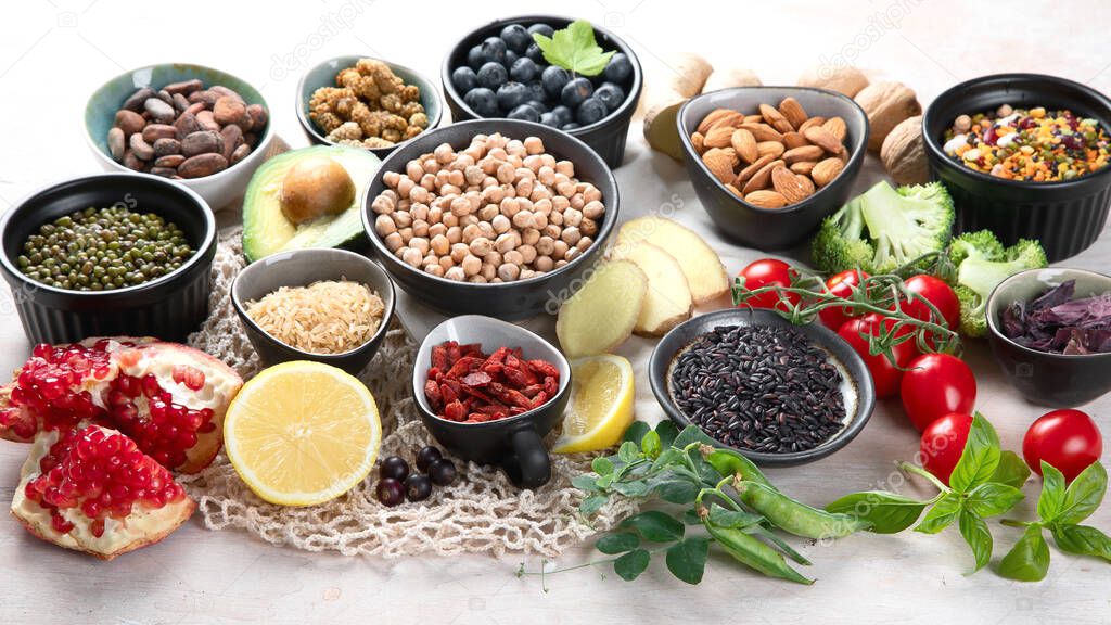 Healthy food selection on white wooden background . Fresh fruits , superfoods an vegatables . High in antioxidants, vitamins, minerals, fiber. 