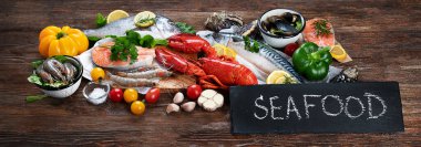 Kırsal ahşap arka planda taze balık ve deniz ürünleri, baharatlar ve sebzeler. Dengeli beslenme ve pişirme konsepti